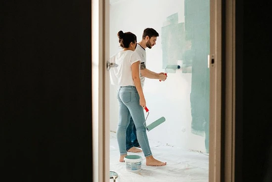 a man and a woman in casual dress getting ready to paint a bedroom